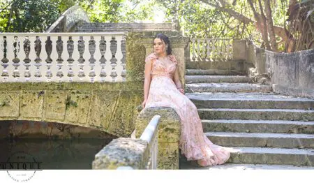 Woman in a pink dress sits on steps.