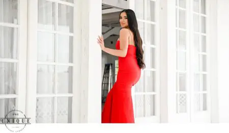 Woman in red dress by white door.