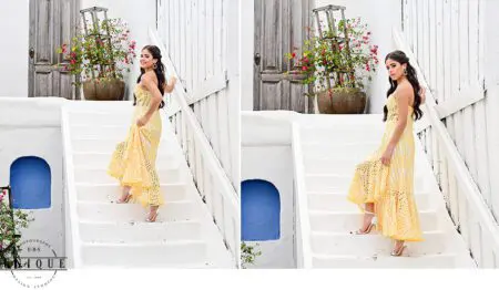 Woman in yellow dress on white stairs.