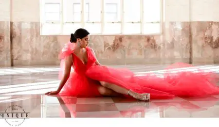 Woman in red dress posing on floor.