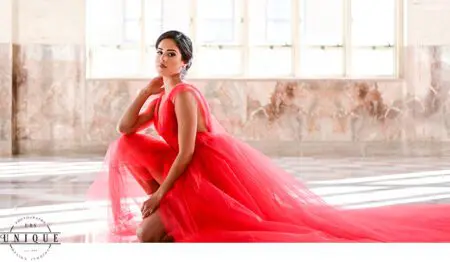 Woman in red dress poses in a studio.
