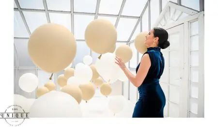 Woman in blue dress with balloons.