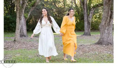 Two women in white and yellow dresses in a forest.