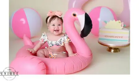 Baby girl in a pink flamingo floatie.
