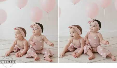 Twin babies in pink heart print outfits.