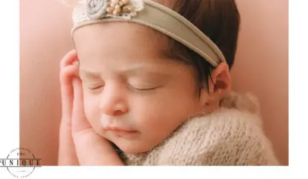 Sleeping newborn baby girl with headband.