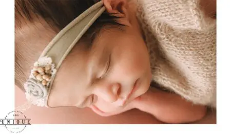 Sleeping newborn baby with headband.