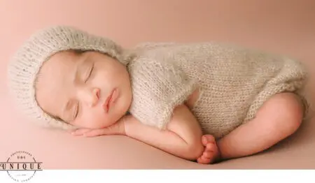 Sleeping newborn baby in knit hat and outfit.