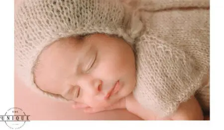 Sleeping newborn baby wearing a knitted hat.