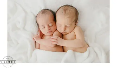 Twin babies sleeping on white blanket.