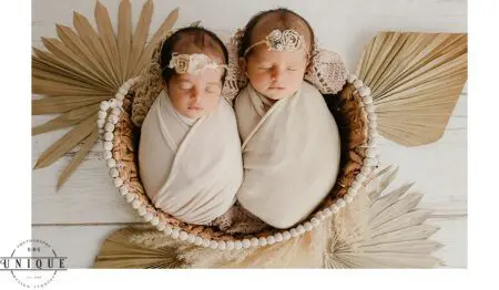 Twin babies sleeping in a basket.