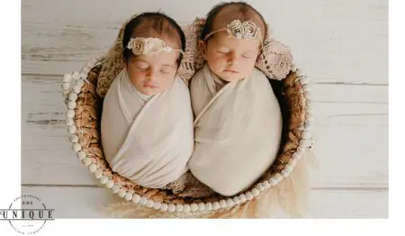 Twin babies sleeping in a basket.
