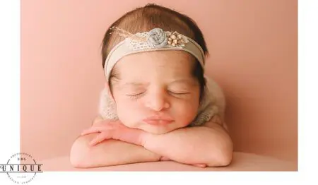 Sleeping newborn baby girl with headband.