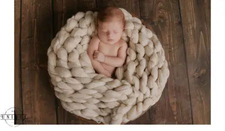 Newborn baby sleeping in a white blanket.