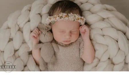 Sleeping newborn baby with flower crown.