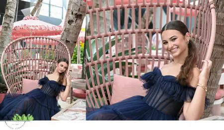 Woman in a blue dress sitting in a wicker chair.