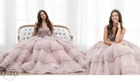 Smiling girl in pink gown with tiara.