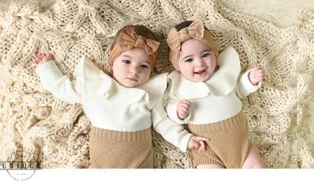 Twin babies on a knitted blanket.