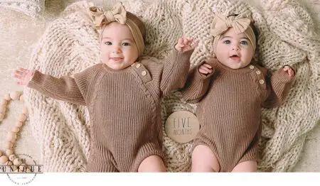 Twin babies in brown sweaters, five months old.