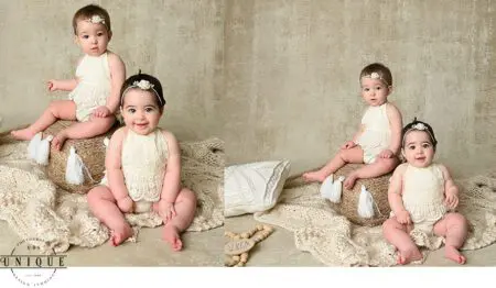 Two babies in white lace dresses on a rug.