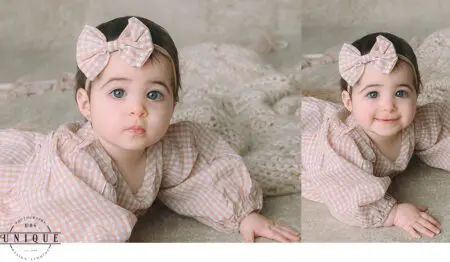 Baby girl in checkered dress with bow.