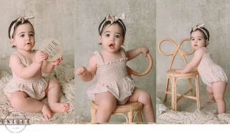 Baby girl in a dress, holding a sign.