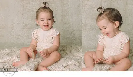 Smiling baby girl in a lace dress.
