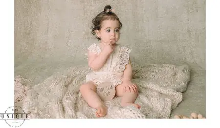 Baby girl in white dress, one year old.