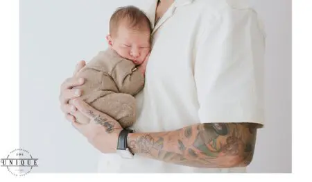 Father cradling sleeping baby in his arms.