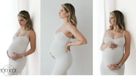 Pregnant woman in white dress, hands on belly.