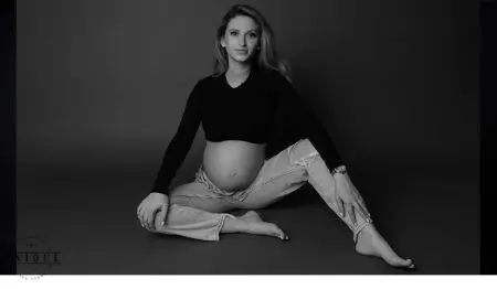 Pregnant woman in black shirt and jeans.