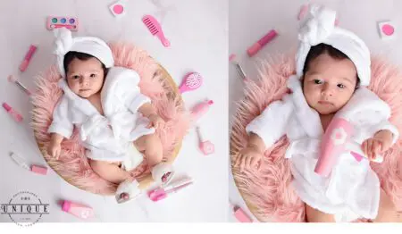 Baby in white robe playing with toys.