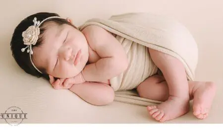 Sleeping newborn baby girl with headband.