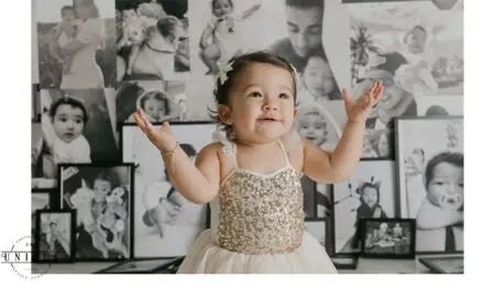 A young girl in a sparkly dress, surrounded by photos.