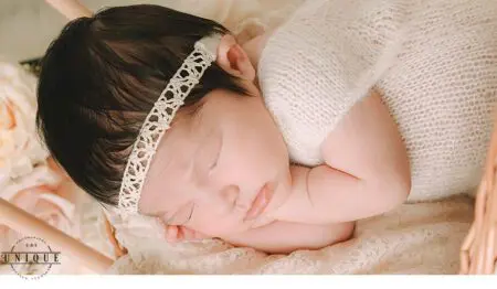 Sleeping newborn baby girl in a basket.
